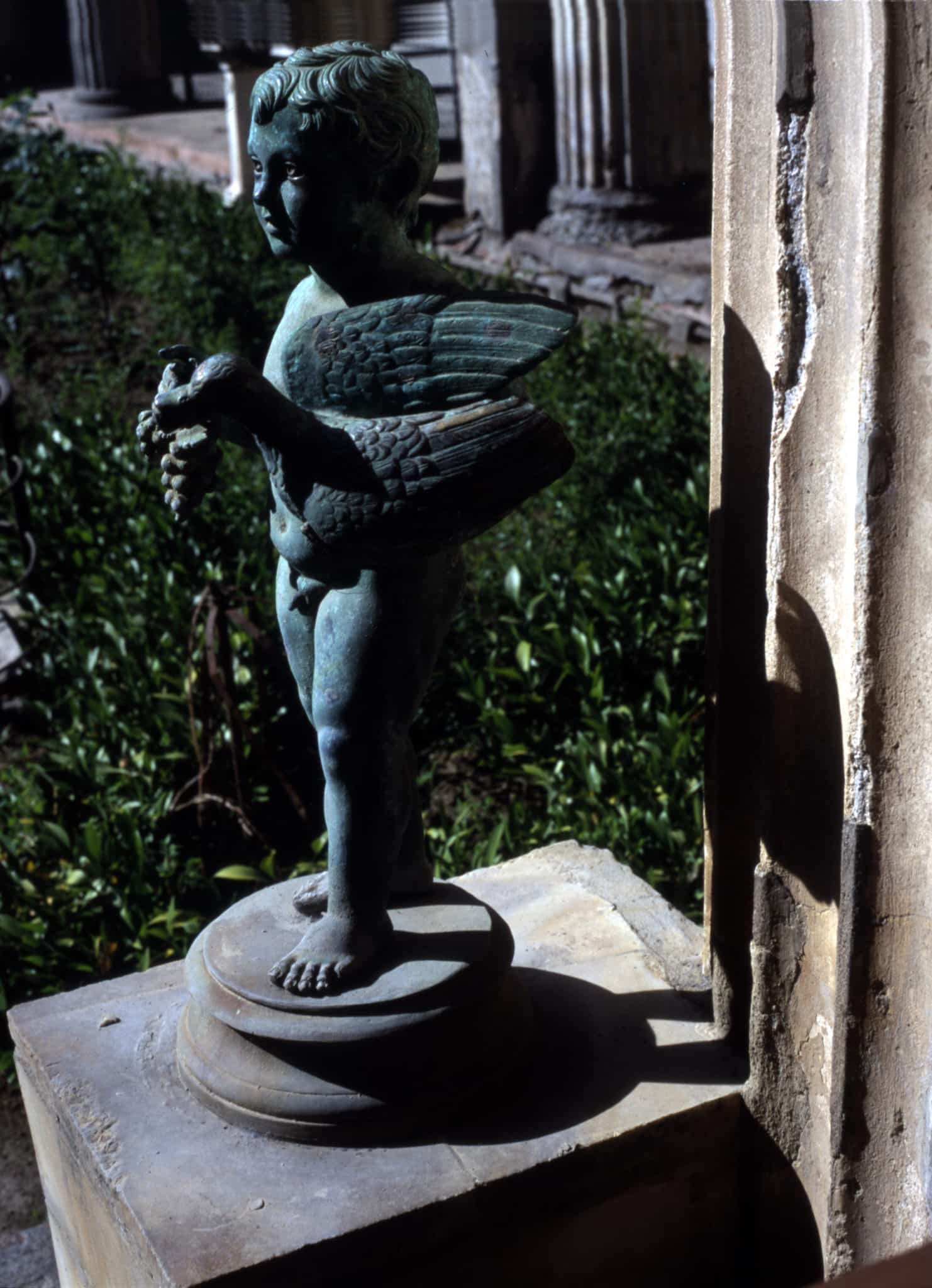 Statue-fontaine d’une petit Amour portant un canard. La statue en bronze, creuse, cache un tuyau d’eau qui sortait par le bec du canard.